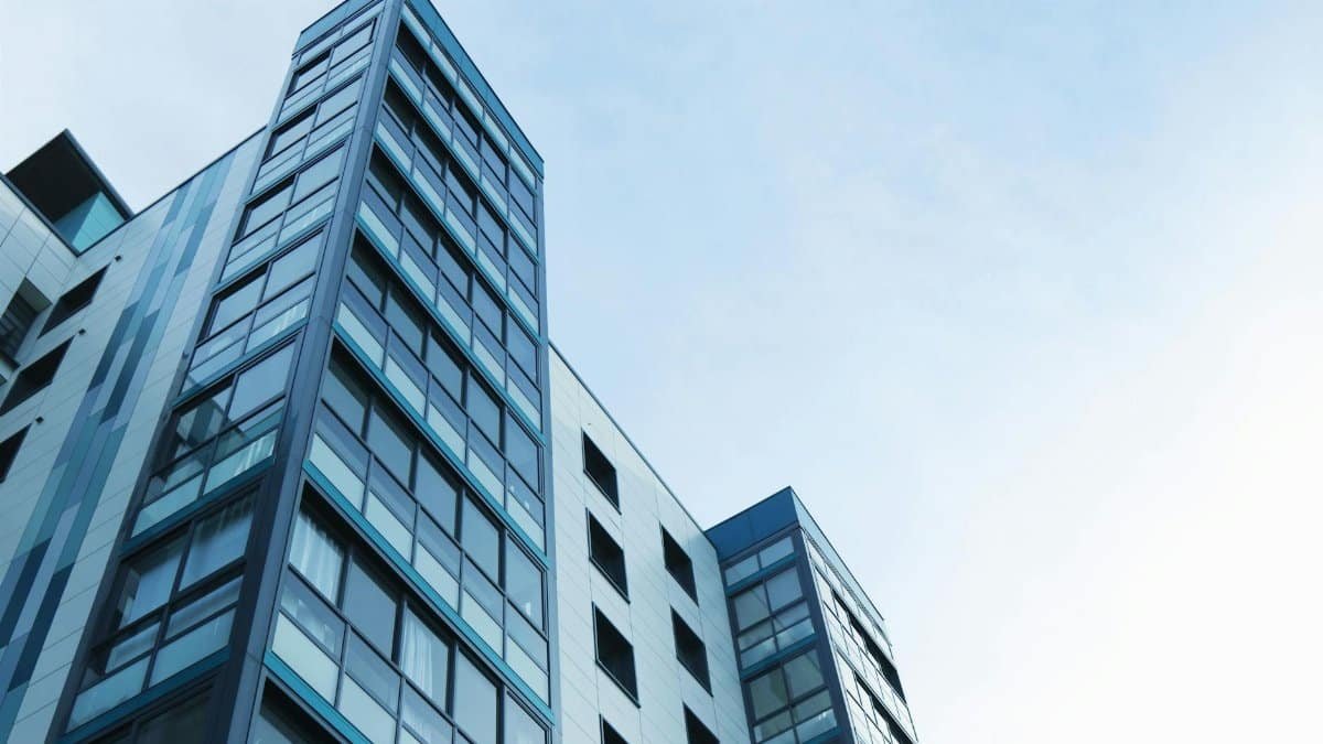 Low-angle view of a modern glass skyscraper against a clear sky in Poole, UK.