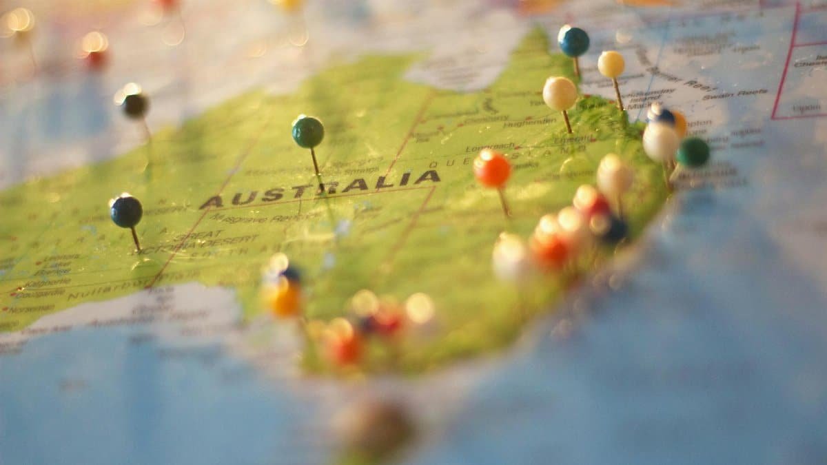 Close-up of a map of Australia with colorful pins marking various cities and destinations.