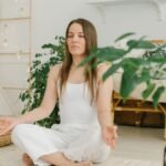 Peaceful meditation scene with a woman practicing mindfulness in a cozy, plant-filled indoor space.