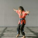 A young martial artist in uniform practicing indoors with focus and energy.