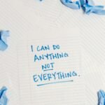 Inspirational message on a notepad surrounded by crumpled paper pieces.