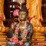 Beautiful Buddha statue surrounded by ornate floral decorations, symbolizing spirituality and peace.