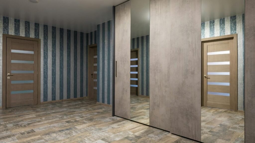 Elegant hallway with striped wallpaper and mirrored wardrobe, offering contemporary interior design inspiration.