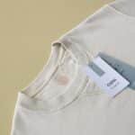 Minimalist beige sweatshirt displayed with tags on a yellow background, perfect for e-commerce.