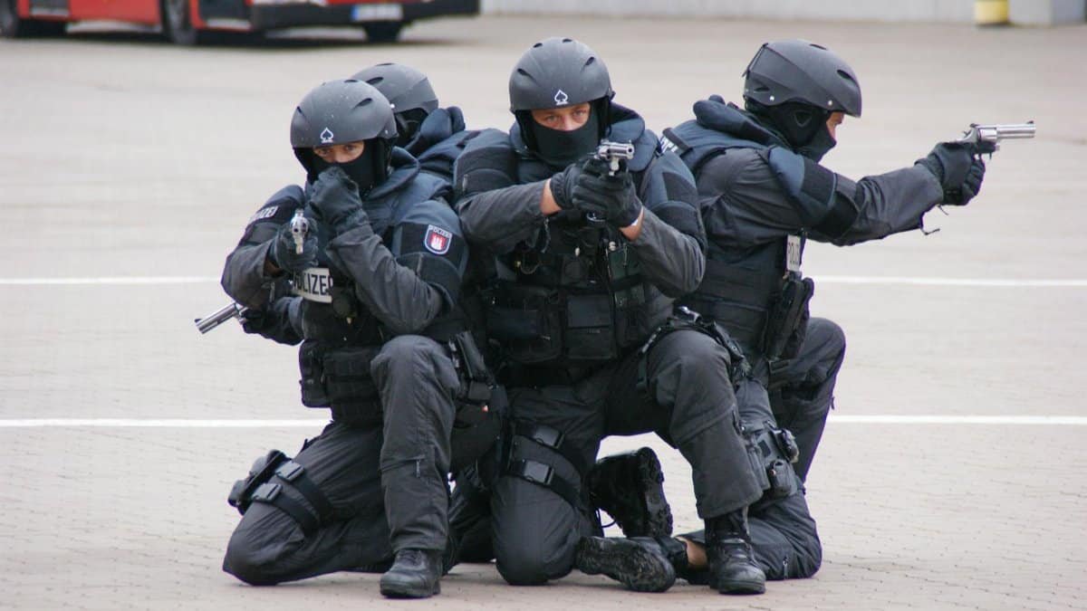 SWAT team conducting tactical training exercise with weapons and protective gear.