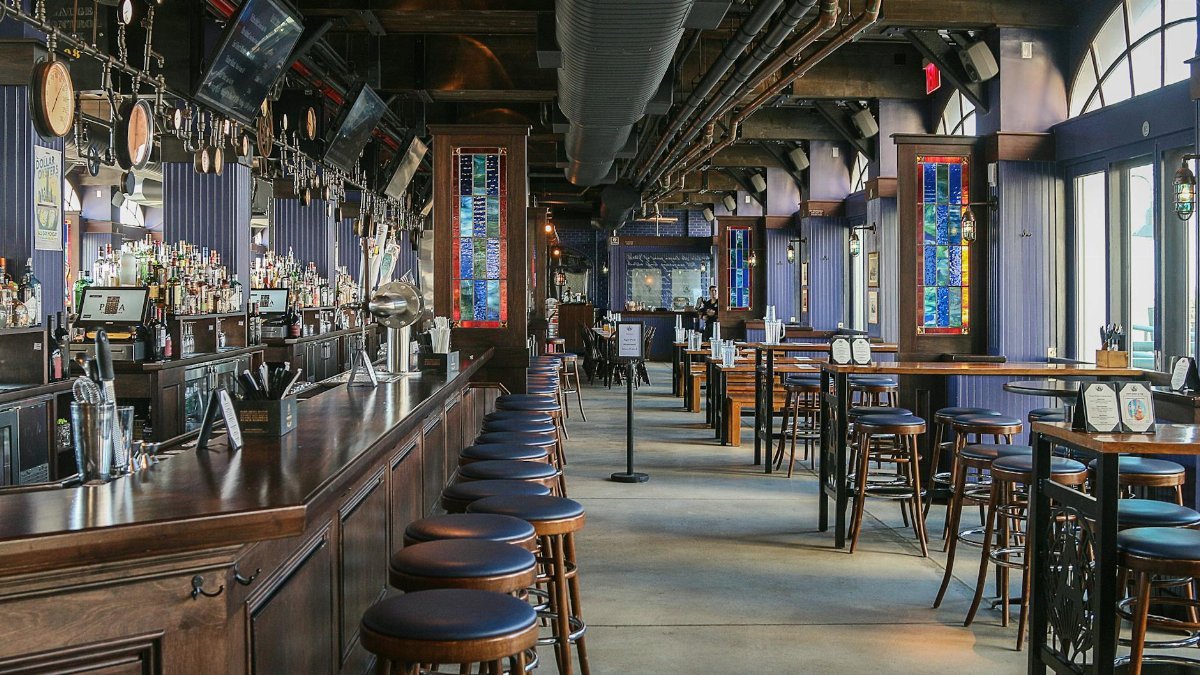 A spacious bar interior with wooden furnishings and colorful stained glass windows in Riverhead, NY.