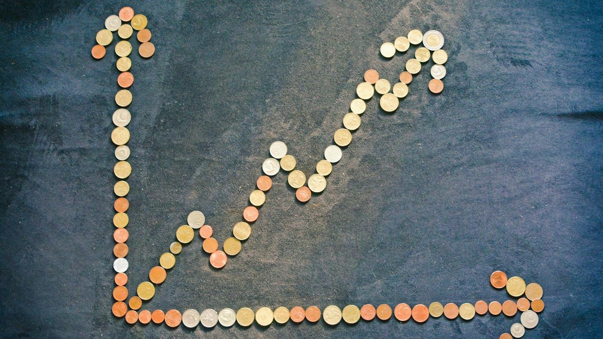 An upward trend graph made from coins representing financial growth and success.