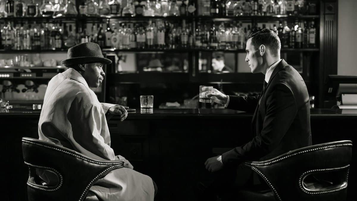 A cinematic, noir-style meeting in a dimly lit bar with a tense atmosphere.