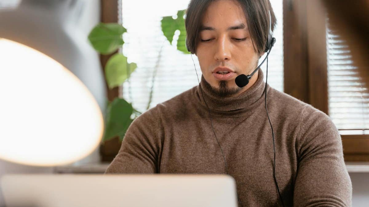 Call center operator with a headset working from home office, focused on customer support.