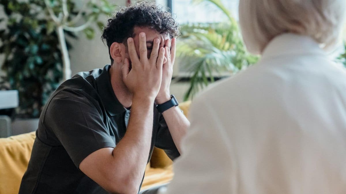 Man seeking support in therapy, expressing emotions during an indoor counseling session.