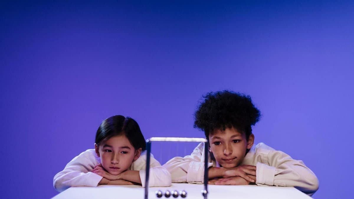 Two children engaging with a Newton's Cradle, fostering interest in physics and science learning.