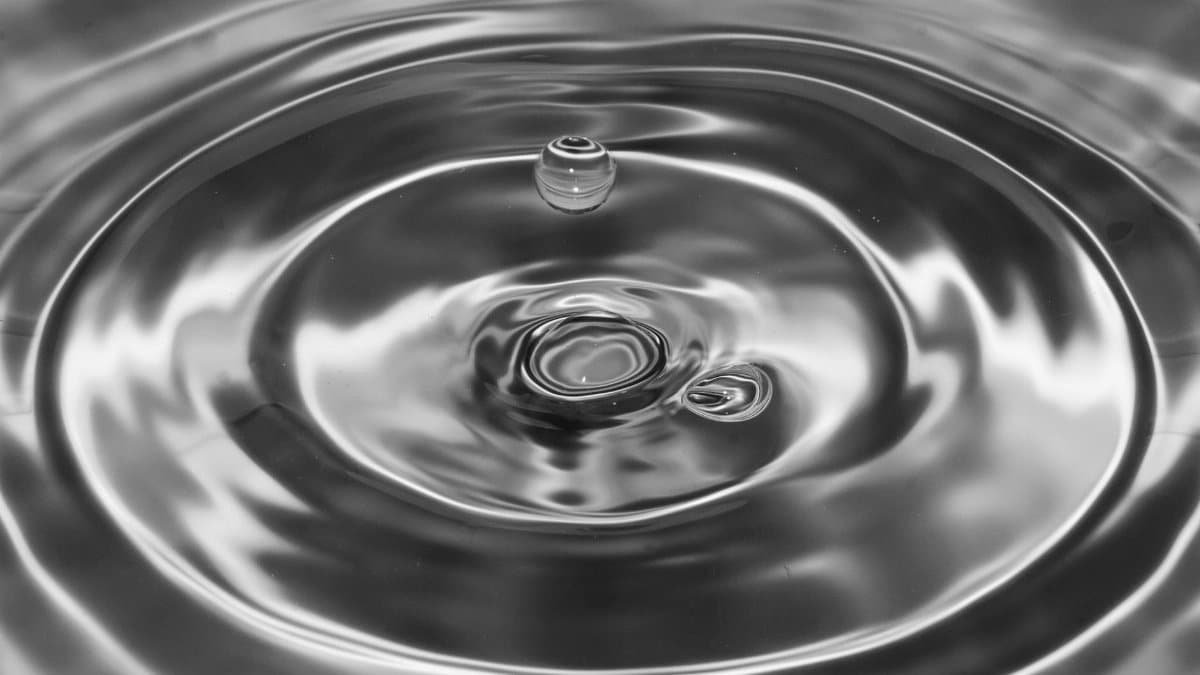 A captivating black and white macro shot capturing water drop ripples in a perfect splash.