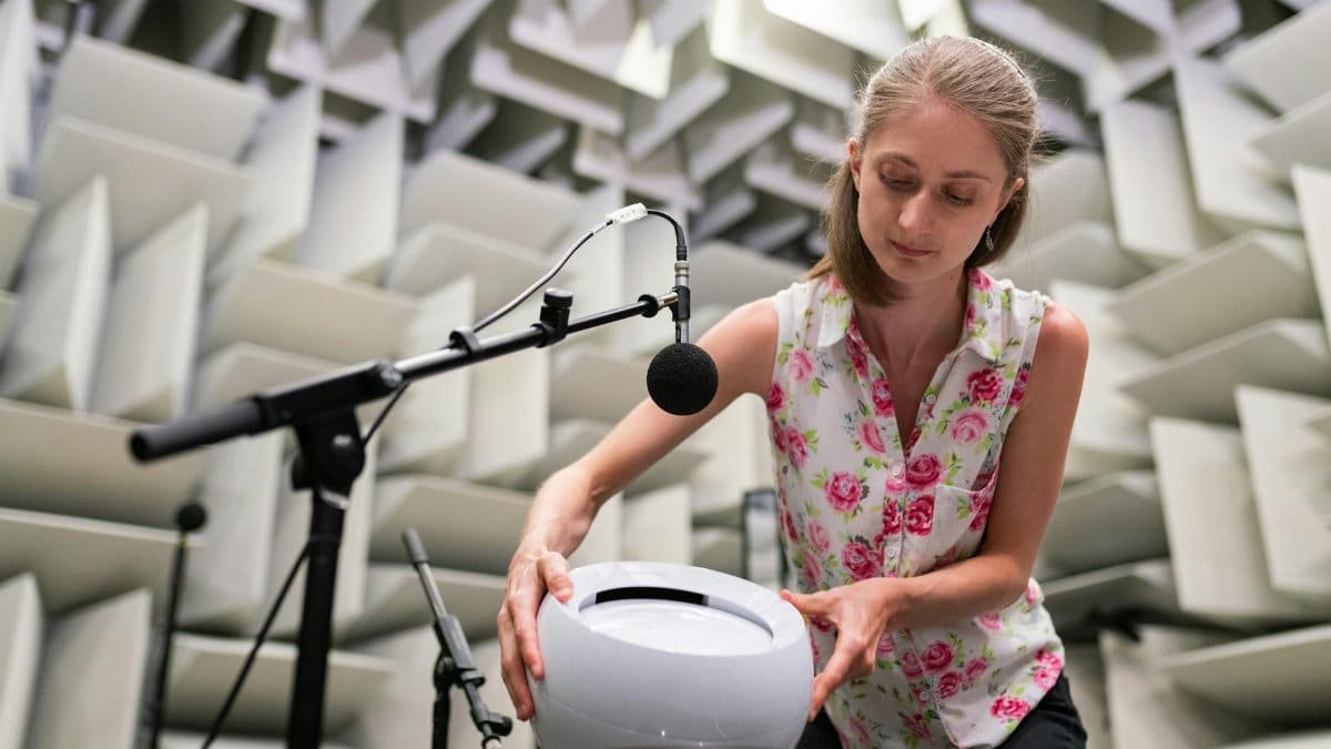 Female engineer working with sound equipment in anechoic chamber, showcasing sound testing and technology.