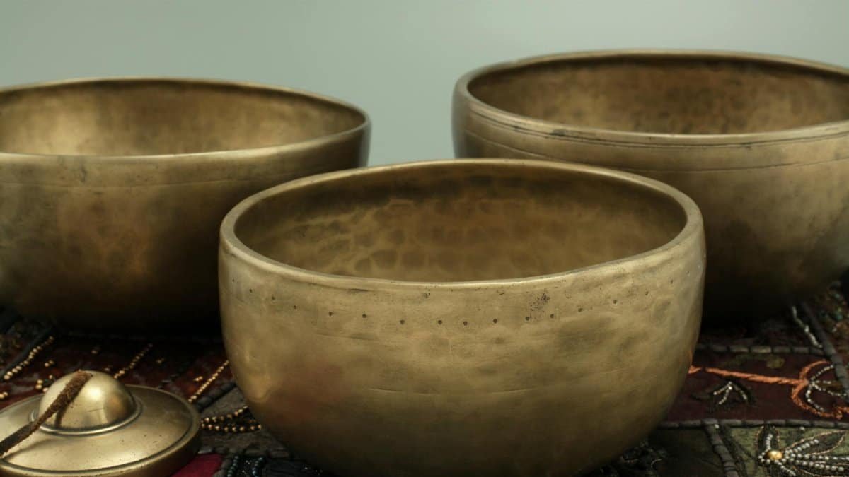Elegant brass singing bowls on a decorative fabric background. Perfect for meditation and sound therapy.