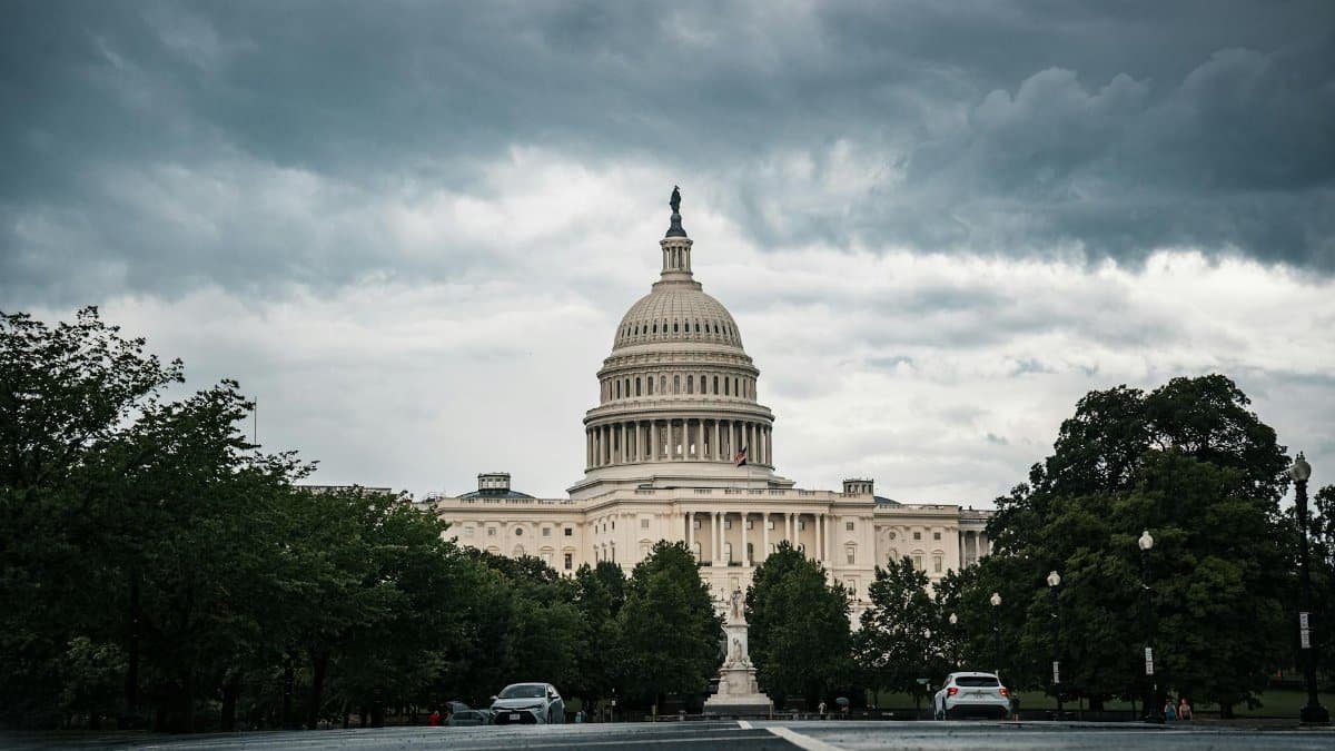 A dramatic view of the US Capitol under cloudy skies in Washington, DC.