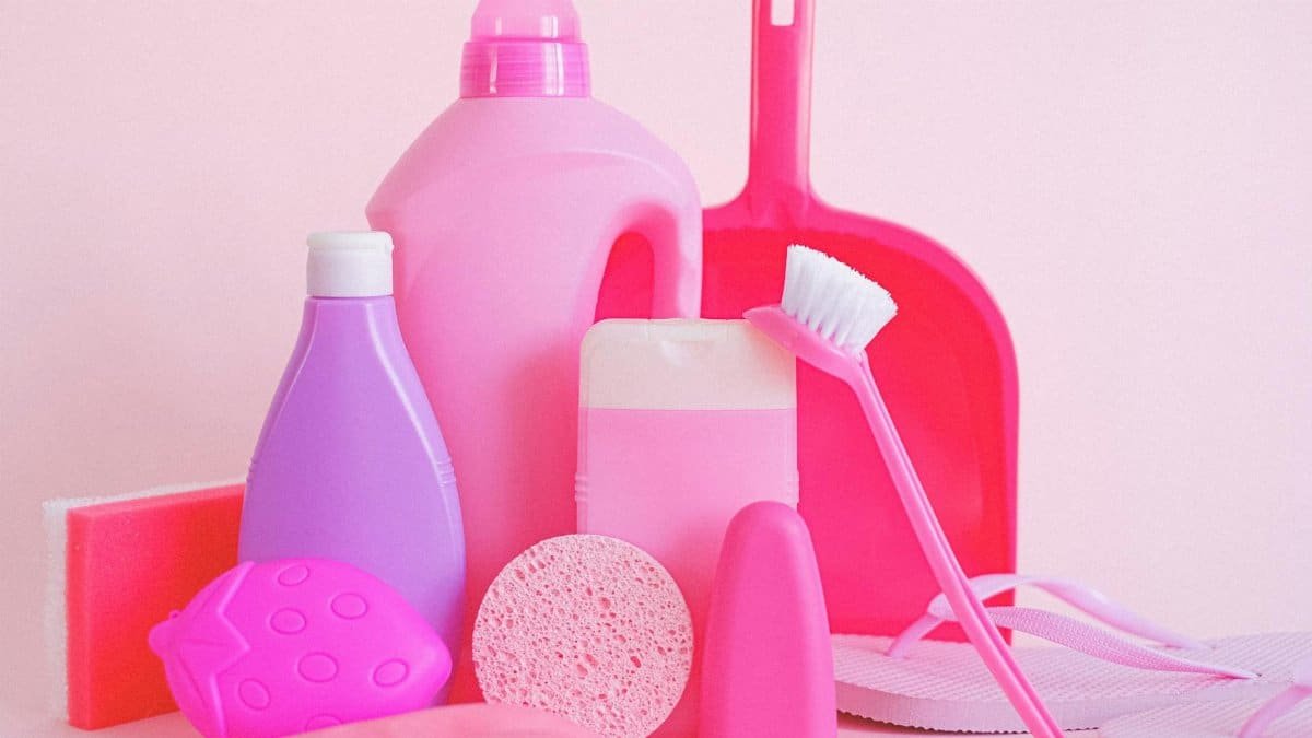 A vibrant collection of cleaning products on pink background, showcasing everyday household essentials.