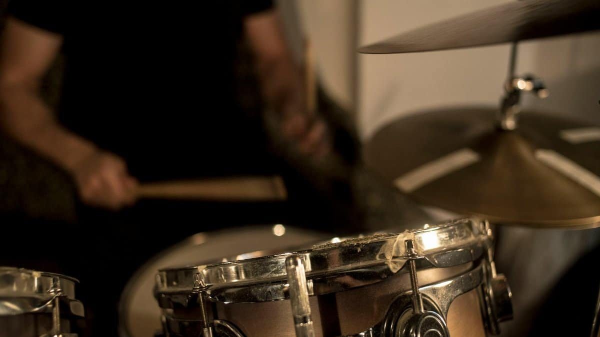 A focused shot of a drummer playing a drum set, capturing rhythm and motion.