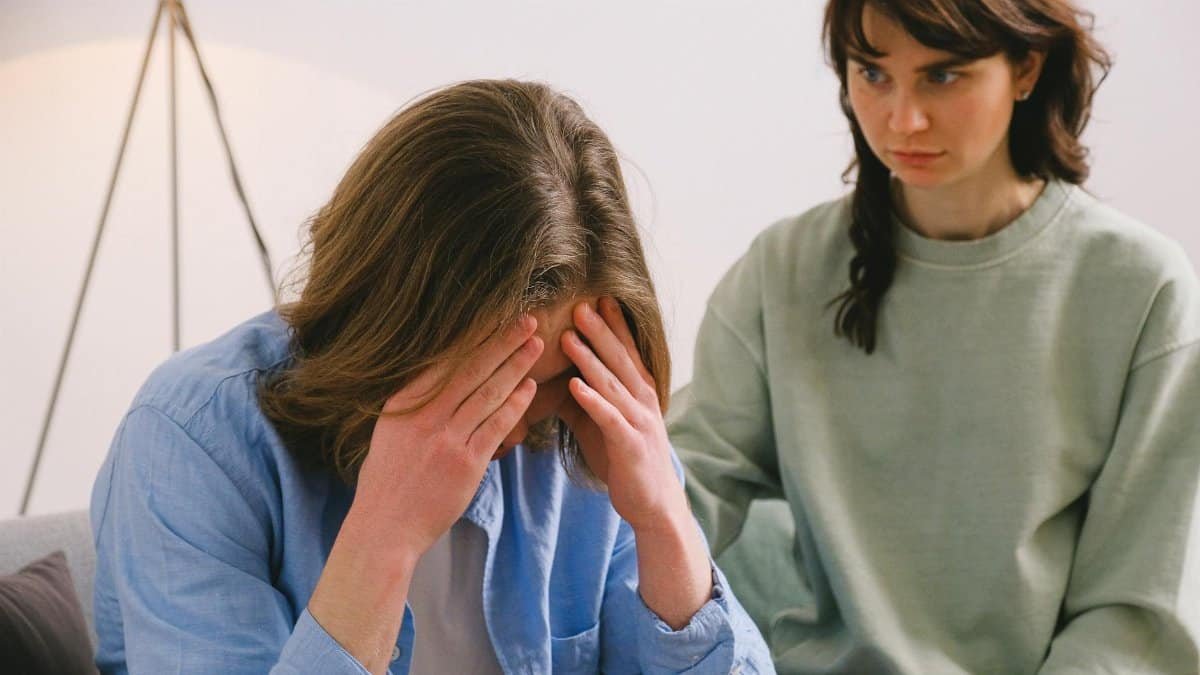 A couple in a tense discussion indoors, depicting stress and mental health focus.