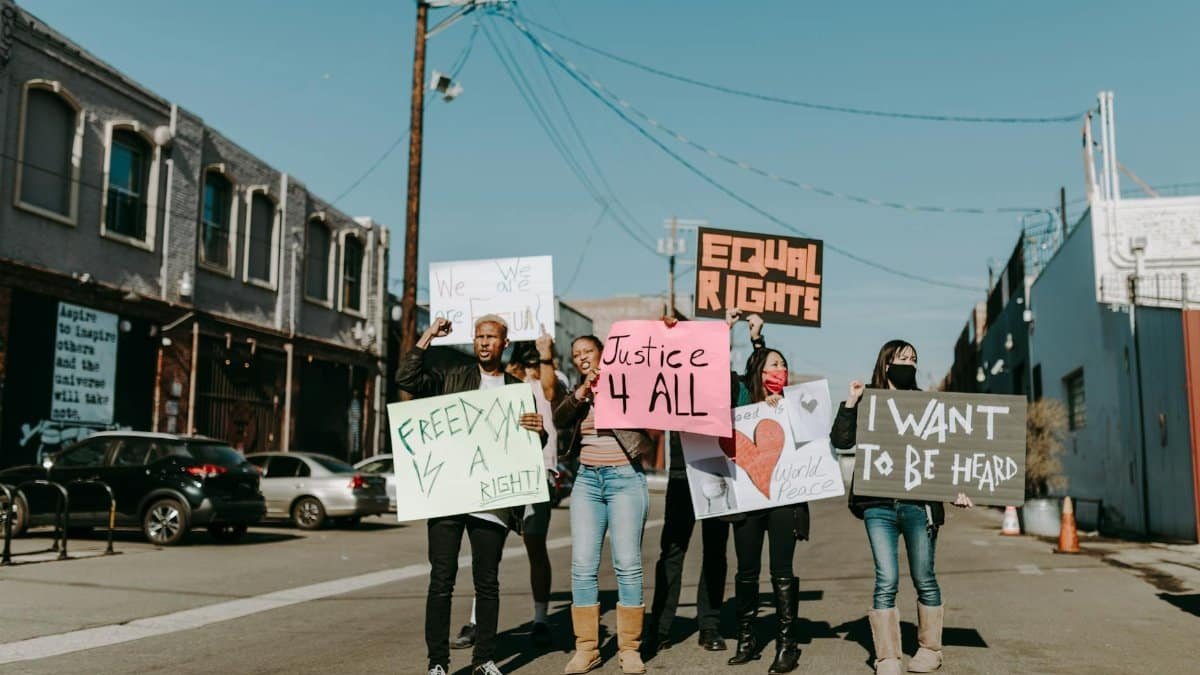 A diverse group of people protesting for freedom and justice outdoors.