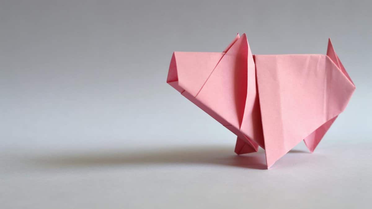 A pink paper origami pig, showcasing traditional Japanese folding art.