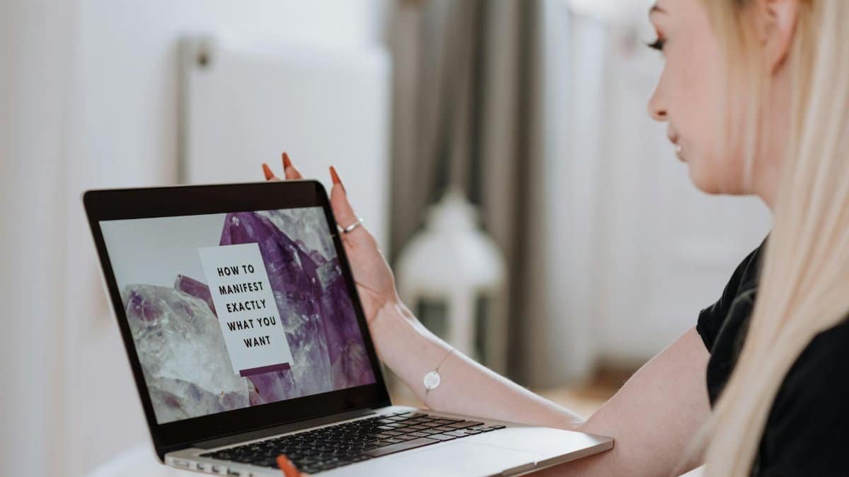 Woman engaging in an online manifestation course, focused and inspired.
