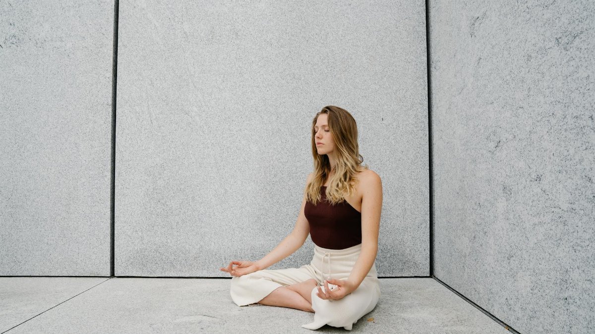 Young woman practicing yoga meditation indoors with calm expression and peaceful atmosphere.