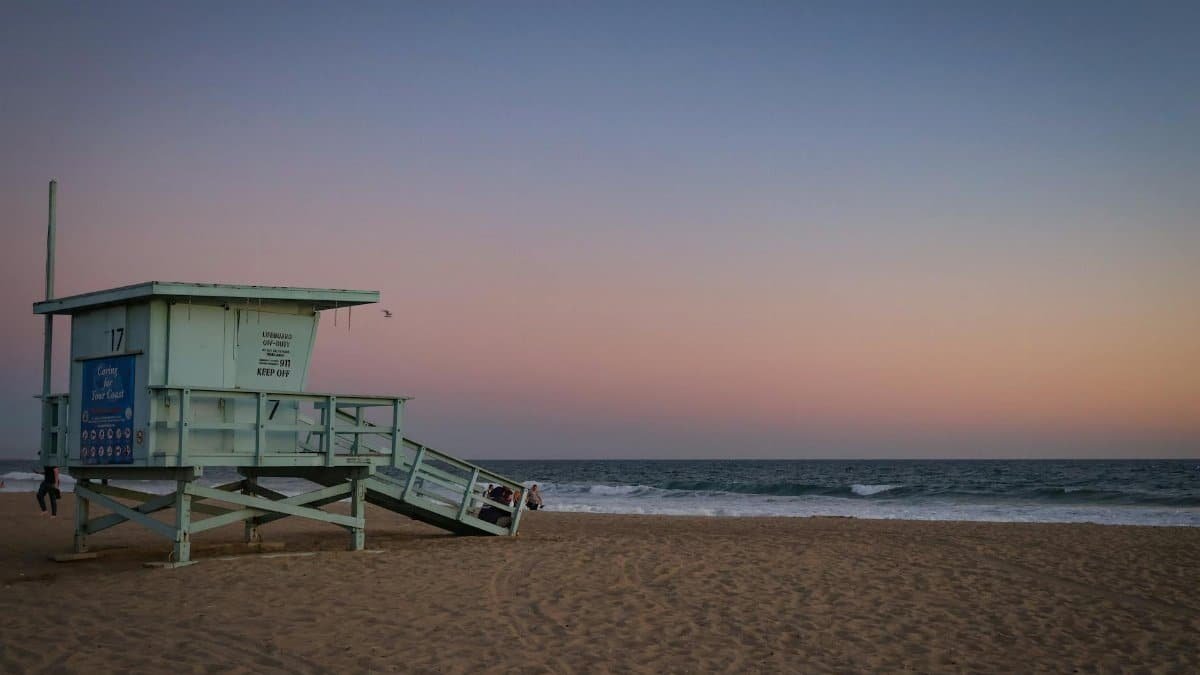 Beautiful dusk scene at Santa Monica Beach with a lifeguard tower and pastel sky, capturing the essence of a summer evening.