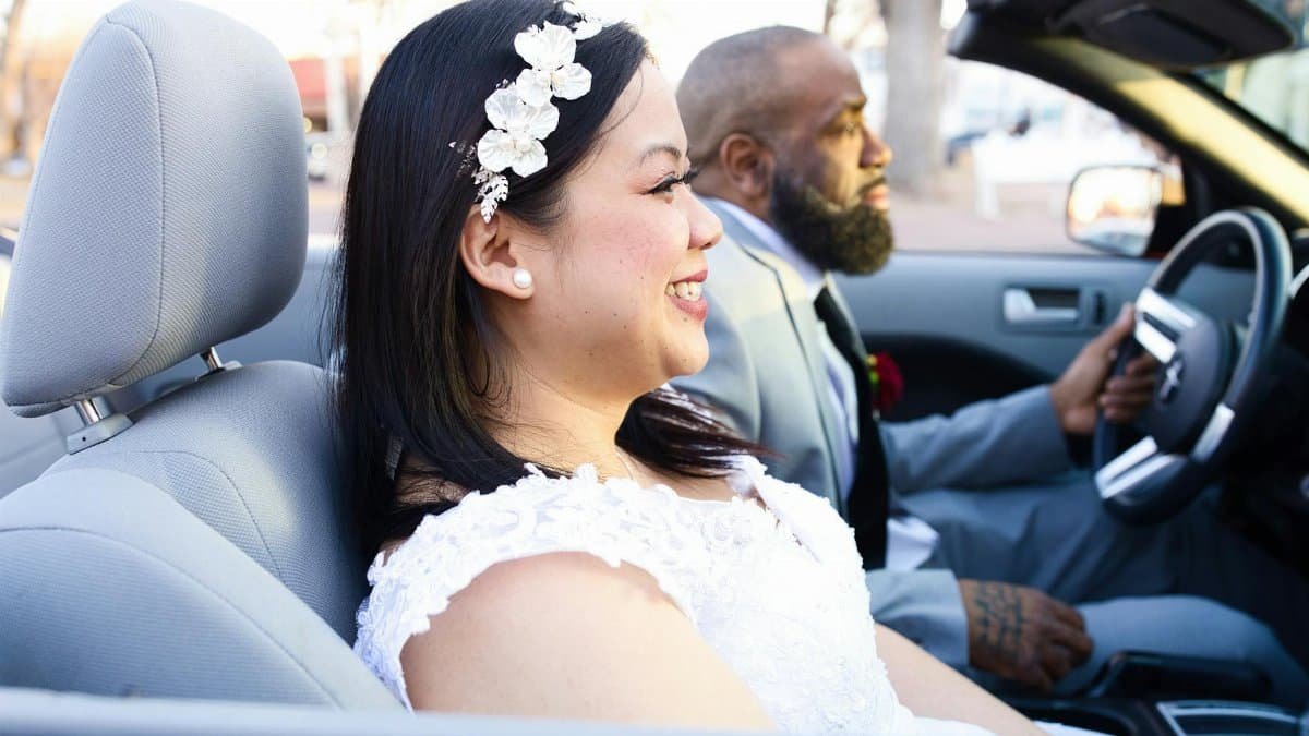 Newlywed couple happily driving a convertible in Albuquerque, New Mexico.