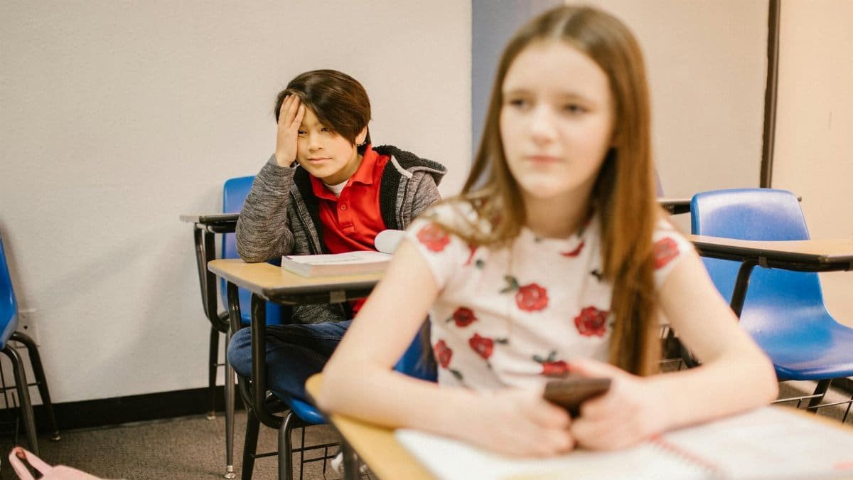 Two students in a classroom setting, focused on their studies.