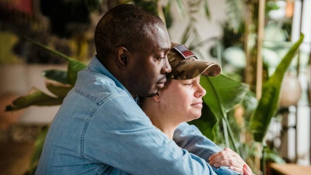 A soldier and partner share a loving embrace indoors, symbolizing reunion and love.