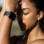 A woman meditates outdoors with eyes closed, embodying tranquility and focus.