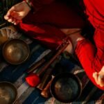 A person meditating outdoors with Tibetan singing bowls, creating a peaceful atmosphere.