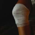 A detailed view of a bandaged knee indicating injury care and healing process.