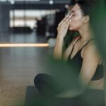 Peaceful woman practicing yoga indoors with eyes closed, focusing on breathing and relaxation.