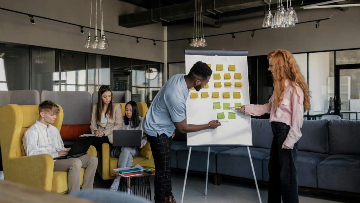 A diverse group of professionals collaborating with sticky notes in a modern office environment.