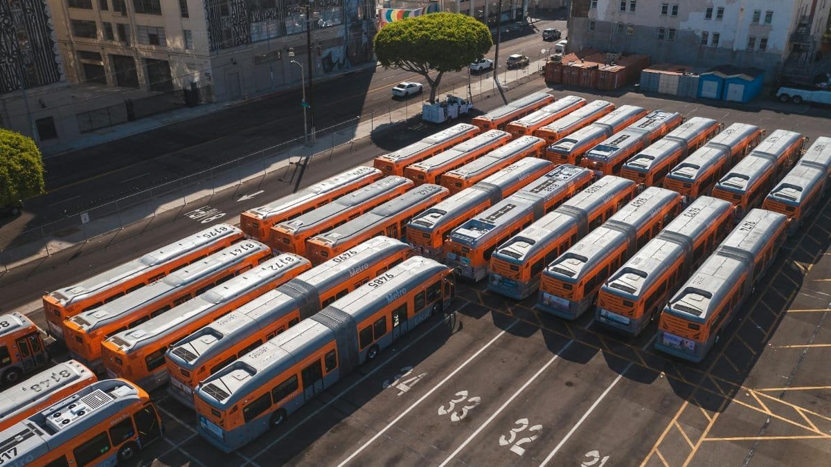 Drone shot showcasing multiple orange buses parked in Los Angeles urban area