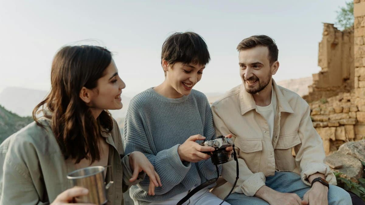 Three friends sharing a joyful moment with a camera in the outdoors, surrounded by ruins and nature.