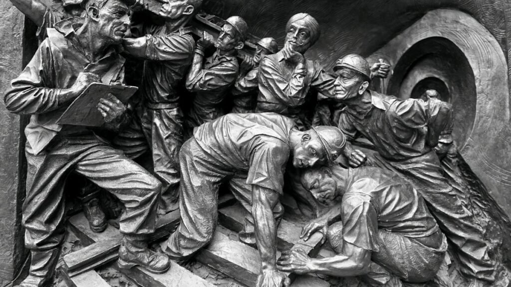 Detailed relief showing a group of miners in action, capturing the essence of teamwork and labor.