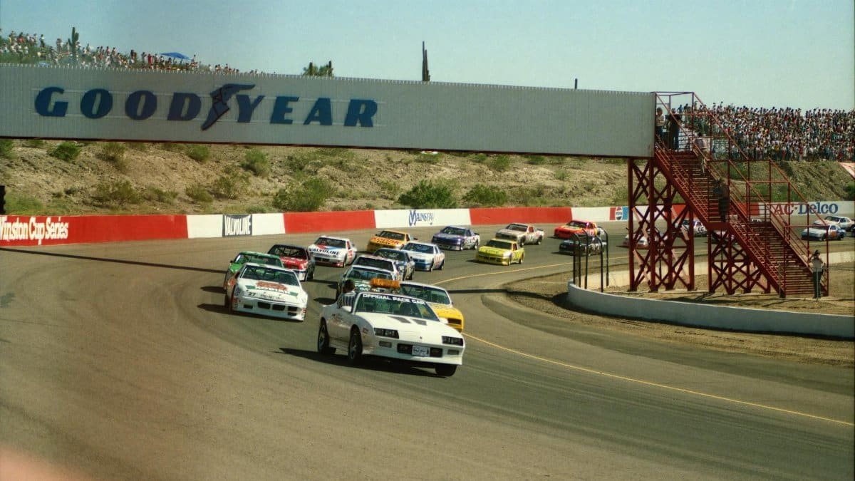 High-speed NASCAR race cars navigating a turn during a thrilling race at Avondale track.
