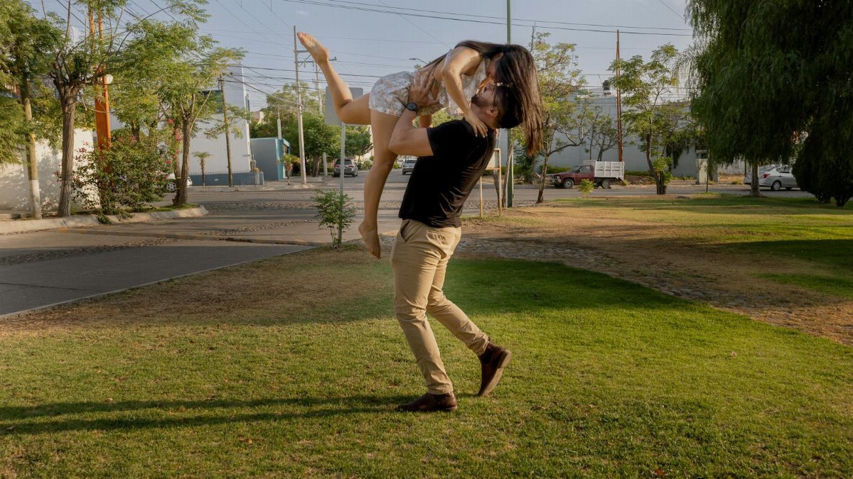 A couple joyfully embracing outdoors in San Luis Potosí park, capturing romance and happiness.