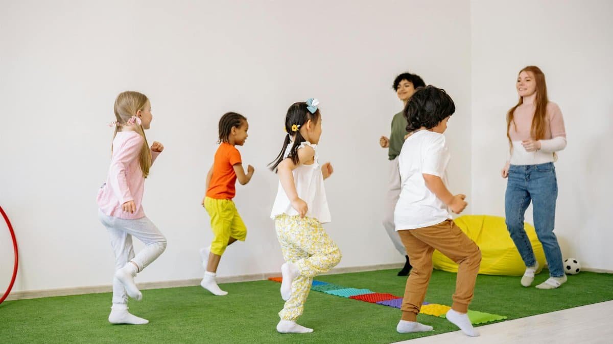 Group of children engaged in fun activities indoors with teachers.