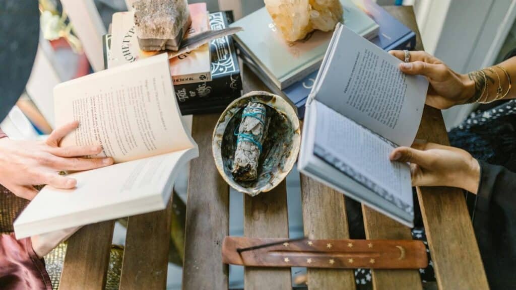 A cozy indoor setup for spiritual reading and crystal healing with books, crystals, and incense.