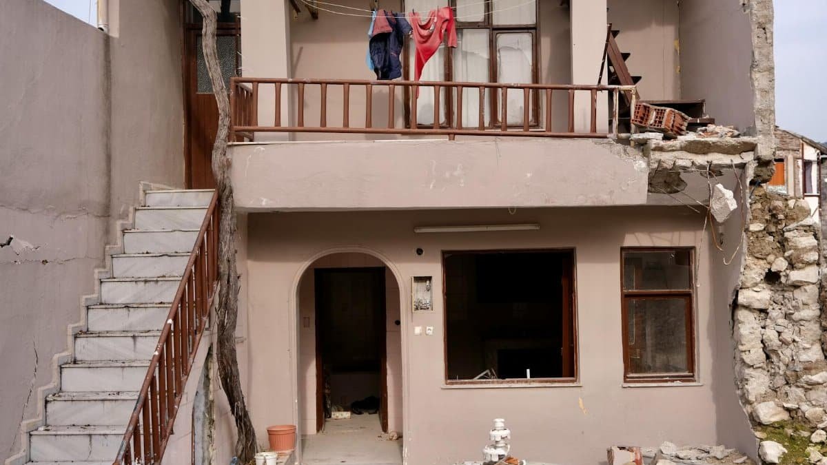Damaged residential building facade in Hatay, Türkiye, showing earthquake impact.