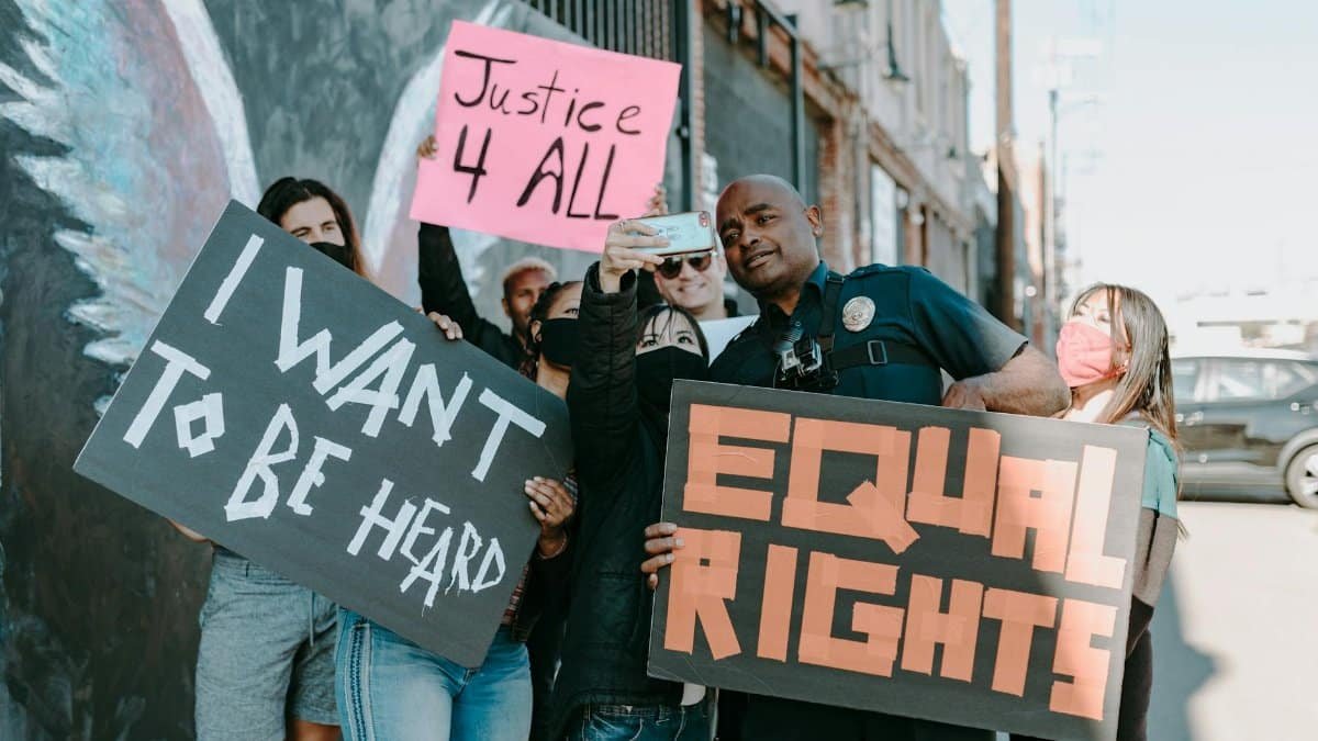A diverse group of protesters holding signs advocating for justice and equal rights.