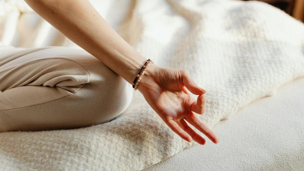 Serene image of a woman practicing meditation on a bed, embracing tranquility and relaxation.