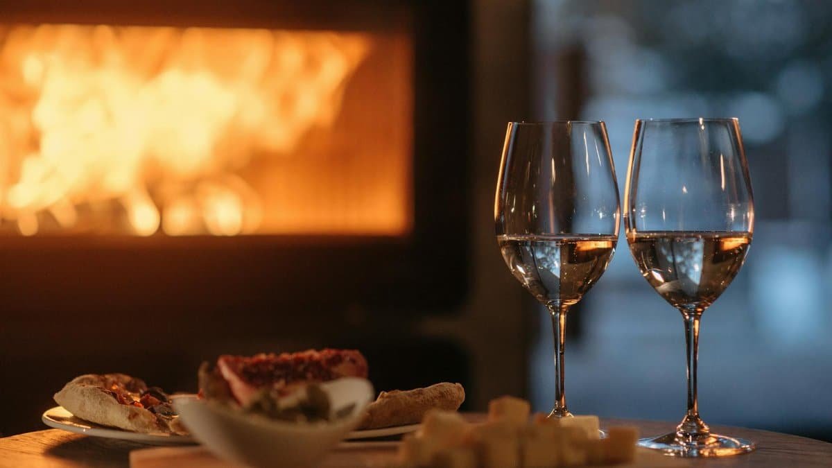 Intimate dining by the fireplace with wine and appetizers, perfect for a cozy winter evening.