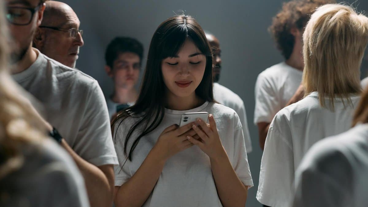 A diverse group of people engaged with their smartphones in a studio setting.