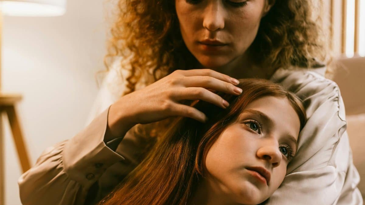 A tender moment of emotional connection and support between two women at home.