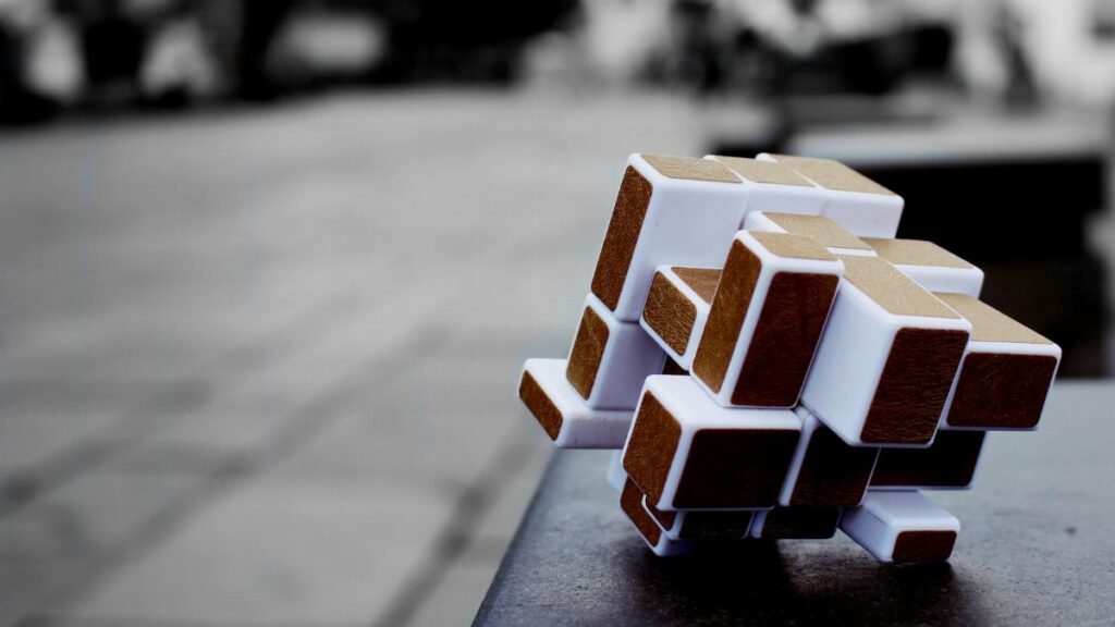 Artistic cube puzzle placed on a surface in an urban setting, capturing depth and focus.
