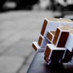 Artistic cube puzzle placed on a surface in an urban setting, capturing depth and focus.